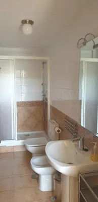 a bathroom with three toilets and a sink and a tub at Apartamentos La Panerona in Tineo