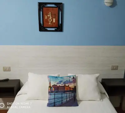 a blue wall with a clock above a bed at Hostal Fisterra in Lugo