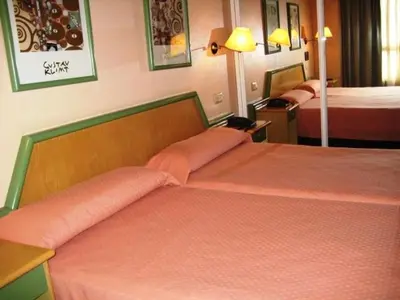 a hotel room with two beds with orange sheets at Puente Romano in Ourense