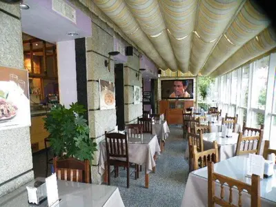 a dining room with tables and chairs in a restaurant at Puente Romano in Ourense