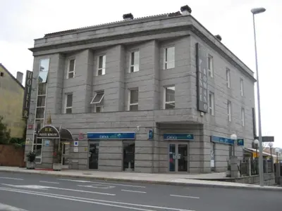 a large stone building on the corner of a street at Puente Romano in Ourense