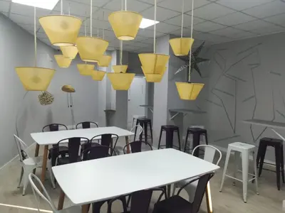 a room with tables and chairs and pendant lights at Augas Quentes Hostel in Ourense