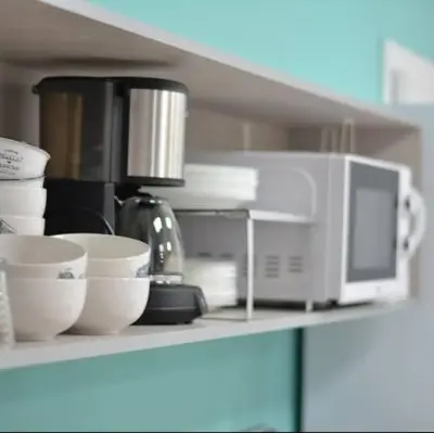 a kitchen counter with bowls and a microwave on it at Augas Quentes Hostel in Ourense