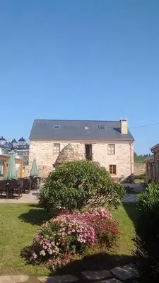 a large stone building with some flowers in front of it at Alén do Mis - Hotel Rural in Foz