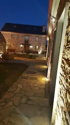 a stone walkway leading to a building at night at Alén do Mis - Hotel Rural in Foz