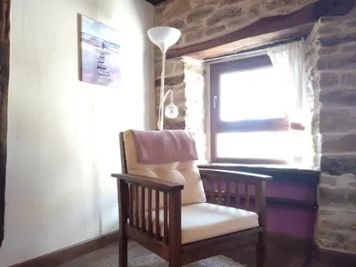 a chair sitting in a room with a window at CASA RURAL Calma del Lago in Triufé