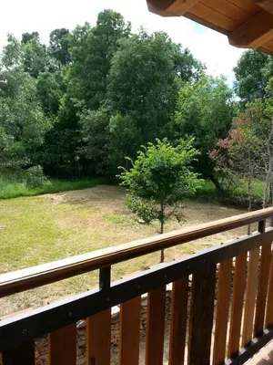 a view of a yard from a wooden deck at CASA RURAL Calma del Lago in Triufé