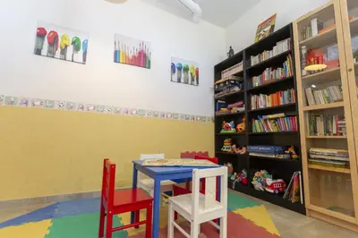 a room with a table and two chairs and bookshelves at Apartamentos Turísticos Playa de Tapia in Tapia de Casariego
