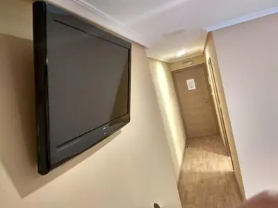 a flat screen tv hanging on a wall in a room at Hostal Lido in Ourense
