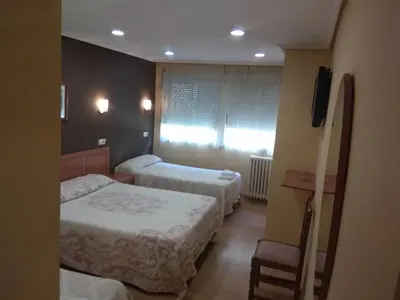 a hotel room with two beds and a window at Hostal Lido in Ourense
