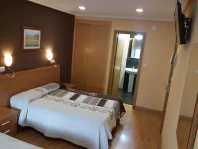 a bedroom with a bed and a television in it at Hostal Lido in Ourense