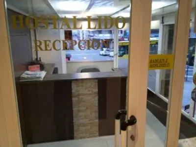 a reflection of a hotel reception desk in a door at Hostal Lido in Ourense