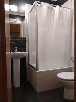 a bathroom with a shower and a sink and a toilet at Hostal Lido in Ourense