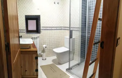 a bathroom with a toilet and a sink at Casa Blanquita in Molinaseca