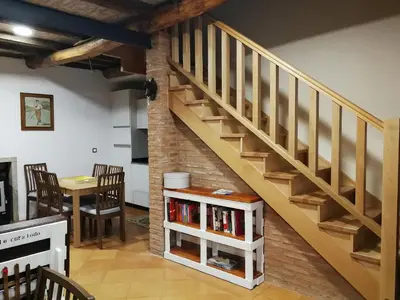 a staircase in a room with a table and chairs at Casa Blanquita in Molinaseca