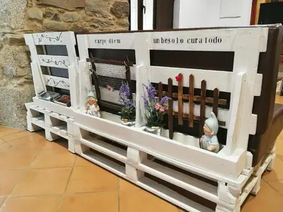 a wooden fence with flowers and figurines on it at Casa Blanquita in Molinaseca
