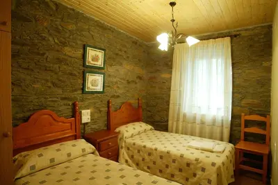a bedroom with two beds and a window at Costa da Egoa in Carral