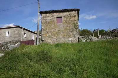 an old stone building with a window in a field at Casa de Labranza Naz in Sober