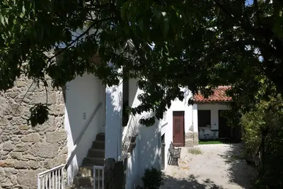 a white building with stairs leading to a door at Casa de Labranza Naz in Sober