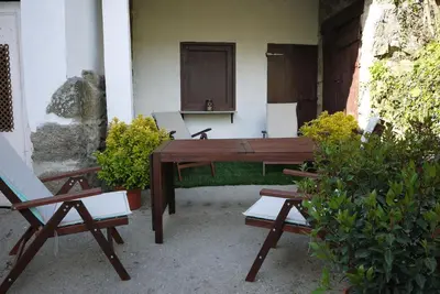 a wooden table and benches in front of a building at Casa de Labranza Naz in Sober