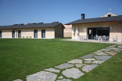 a building with a lawn with chairs and a patio at Alojamiento Ubaldo Nieto in Carracedo del Monasterio