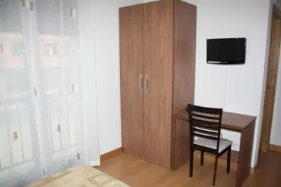 a room with a desk and a chair and a tv at Alojamiento Ubaldo Nieto in Carracedo del Monasterio