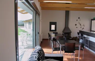 a dining room with tables and chairs and a fireplace at Alojamiento Ubaldo Nieto in Carracedo del Monasterio