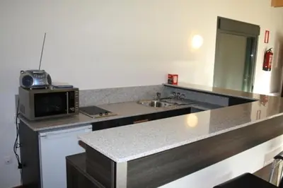 a kitchen with a counter with a microwave and a sink at Alojamiento Ubaldo Nieto in Carracedo del Monasterio