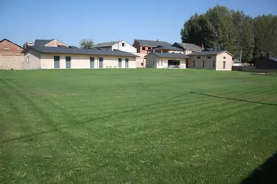 a large grass field with houses in the background at Alojamiento Ubaldo Nieto in Carracedo del Monasterio