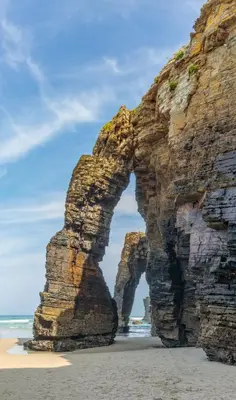 an arch in the rocks on the beach at Villas Las Catedrales in Ribadeo