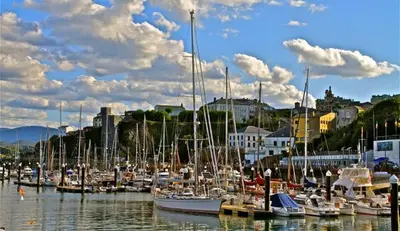 a bunch of boats docked in a harbor with a city at Villas Las Catedrales in Ribadeo