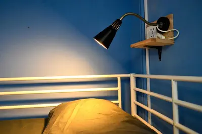 a bedroom with a lamp on a blue wall at Albergue O Fogar de Teodomiro in Santiago de Compostela