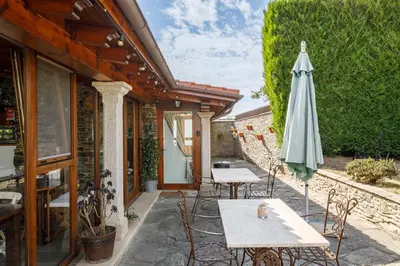 a patio with an umbrella and a table and chairs at Casa Rural Dona María in Ordes