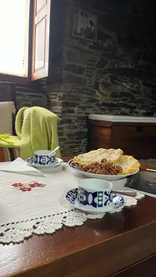 a table with a pie and two cups on it at Casa Rural Dona María in Ordes