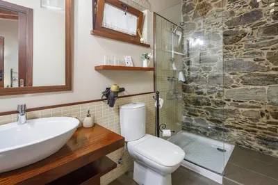 a bathroom with a sink and a toilet and a shower at Casa Rural Dona María in Ordes