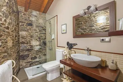 a bathroom with a sink and a toilet and a shower at Casa Rural Dona María in Ordes