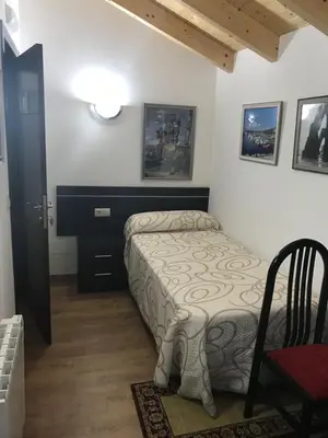 a small bedroom with a bed and a chair at kilometro 15 in Amenal