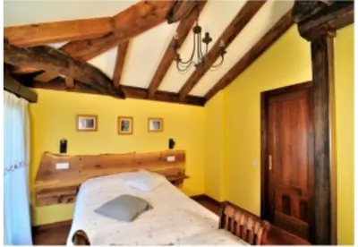 a bedroom with a bed in a room with yellow walls at Casa Corral - Casas de Aldea in Monón