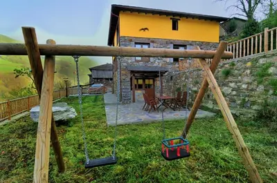 a yard with swings in front of a house at Casa Corral - Casas de Aldea in Monón