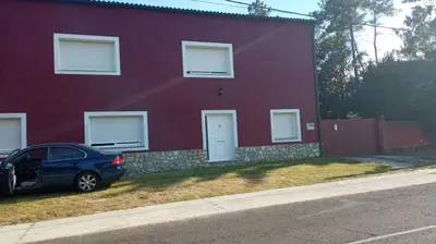 a red house with a car parked in front of it at CASA DE CAMPO TRANQUILA EN VILAR CERCA DE SANTIAGO in Touro
