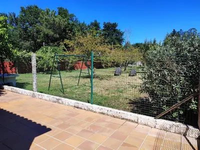 a batting cage with two chairs in a backyard at CASA DE CAMPO TRANQUILA EN VILAR CERCA DE SANTIAGO in Touro