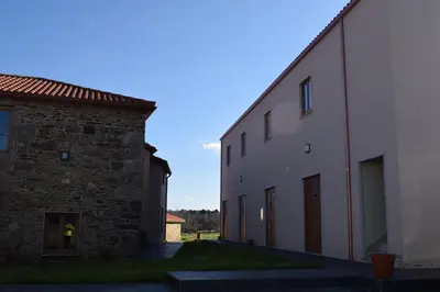an alley between two buildings next to each other at Pensión Albergue Los Caminantes in Ribadiso