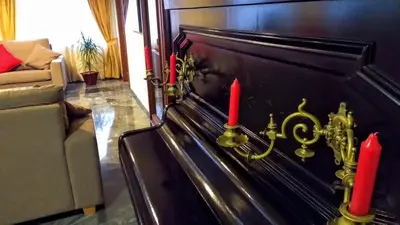 two red candles on a piano in a living room at Hotel Windsor in Santiago de Compostela