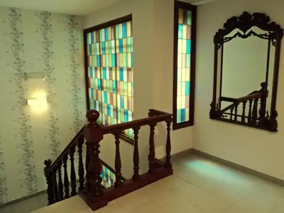 a staircase with a mirror and stained glass windows at Hotel Windsor in Santiago de Compostela