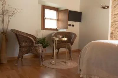 a bedroom with two chairs and a table and a bed at Hostal Pension Artilleiro in Santiago de Compostela