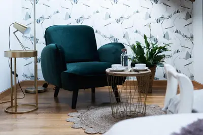 a living room with a green chair and a table at Hostal Pension Artilleiro in Santiago de Compostela