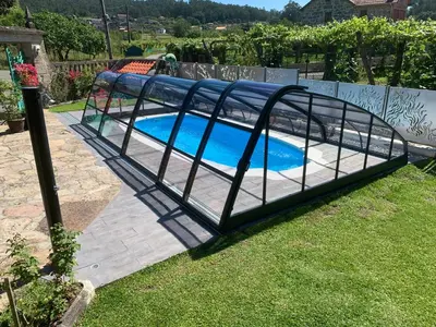a white hammock in front of a house with flowers at Casa de Marcelo in Padrón