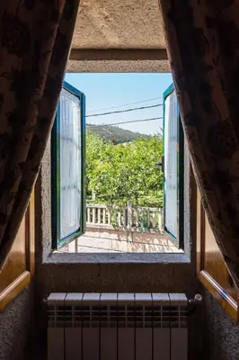 a room with chairs and a table and windows at Casa de Marcelo in Padrón