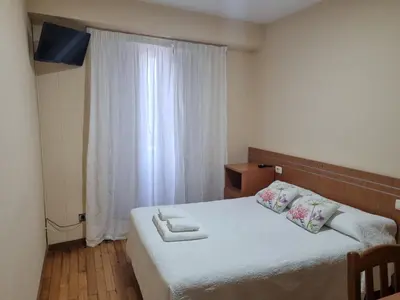 a bedroom with a bed with two towels on it at Hostal O Patron in Santiago de Compostela