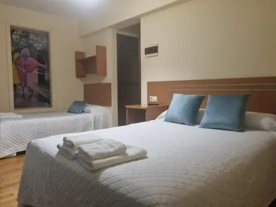 a bedroom with two beds with towels on the bed at Hostal O Patron in Santiago de Compostela